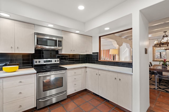 kitchen with decorative backsplash, stainless steel appliances, and a chandelier