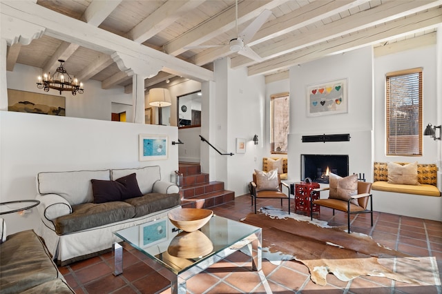 tiled living room featuring beamed ceiling, ceiling fan with notable chandelier, and wood ceiling