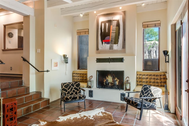 living area with beam ceiling, tile patterned flooring, and baseboard heating