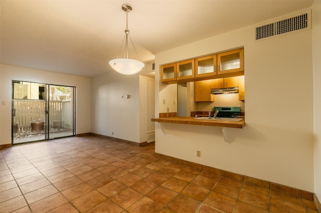 kitchen with sink, kitchen peninsula, pendant lighting, a kitchen bar, and stainless steel stove