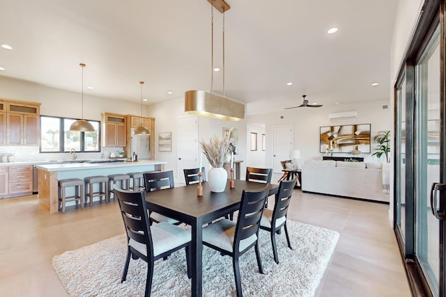 dining room with a wall mounted air conditioner, ceiling fan, and sink