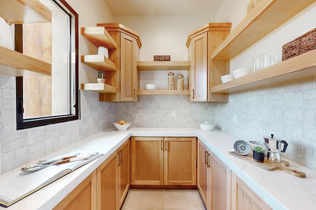 kitchen with light tile patterned floors, light brown cabinetry, and tasteful backsplash