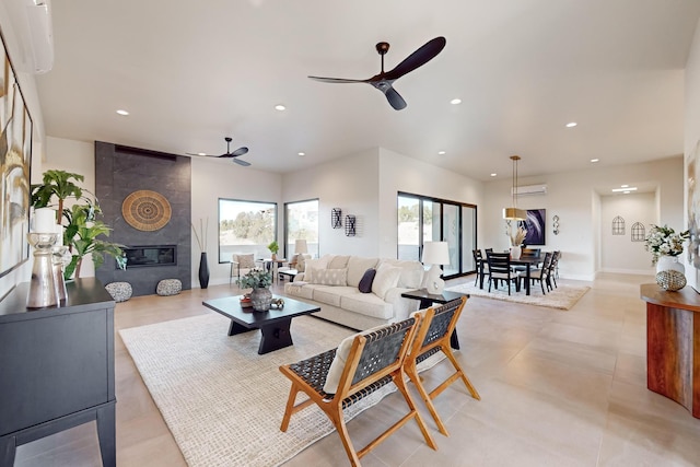 living room featuring a fireplace, an AC wall unit, and ceiling fan