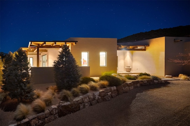 property exterior at twilight featuring a patio