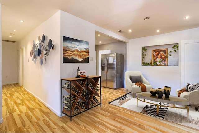 hallway with light wood-type flooring, baseboards, and recessed lighting