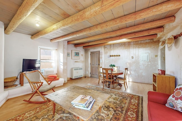 living room with heating unit, beamed ceiling, wood ceiling, and light wood-type flooring