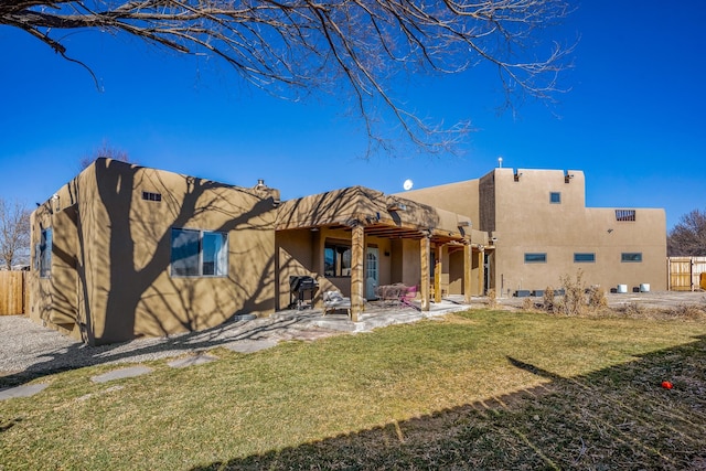 back of property with a patio and a lawn