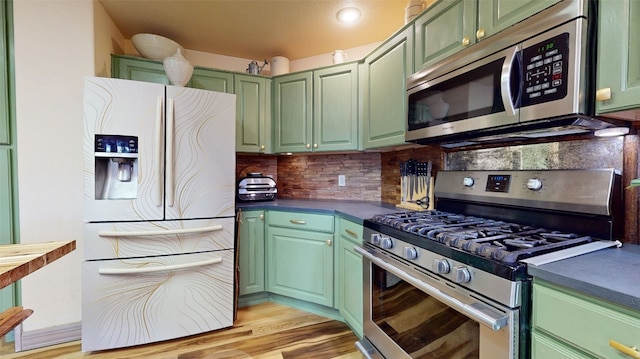 kitchen with stainless steel appliances, light hardwood / wood-style flooring, tasteful backsplash, and green cabinetry