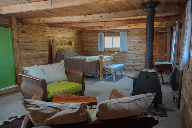 carpeted bedroom with beamed ceiling, a wood stove, wood ceiling, and wood walls