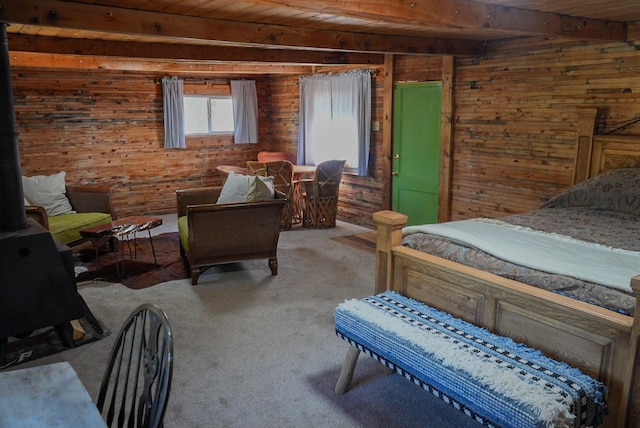 carpeted bedroom with beam ceiling, wooden walls, and wooden ceiling