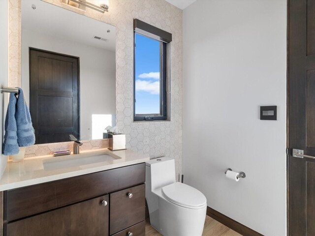 bathroom featuring vanity, hardwood / wood-style flooring, and toilet