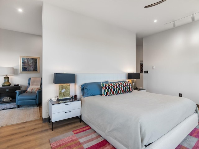 bedroom featuring ceiling fan, hardwood / wood-style floors, and rail lighting