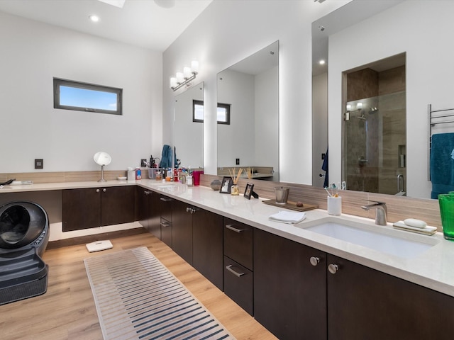 bathroom with hardwood / wood-style flooring, vanity, and a shower with door