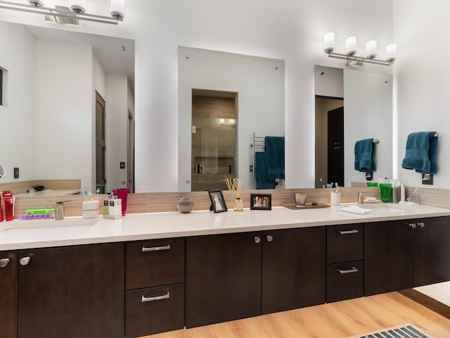 bathroom with vanity, wood-type flooring, and walk in shower