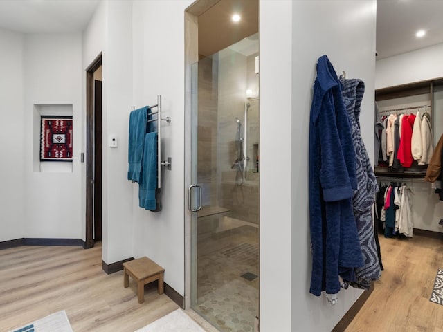 bathroom with hardwood / wood-style floors and an enclosed shower