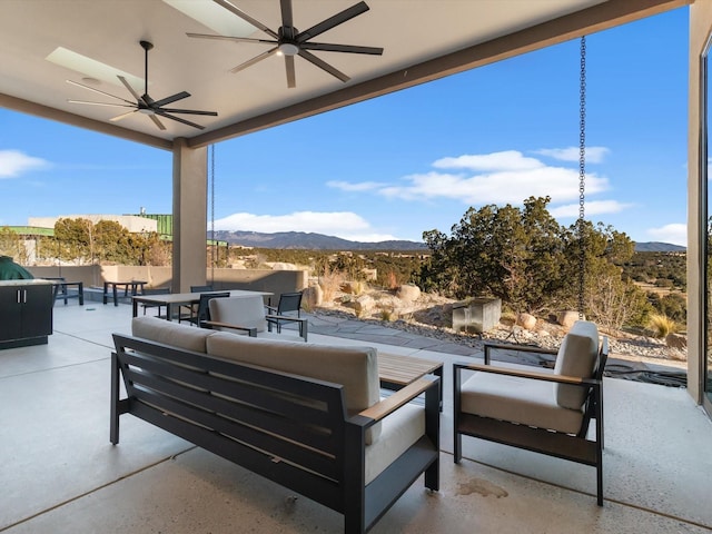 view of patio featuring a mountain view, an outdoor living space, and ceiling fan