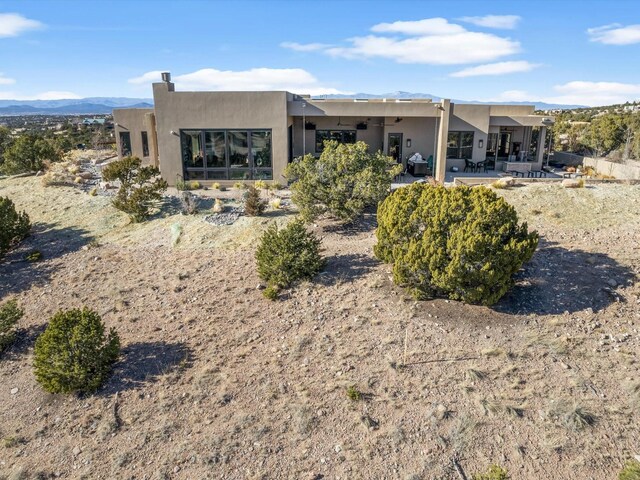 back of property featuring a mountain view and a patio