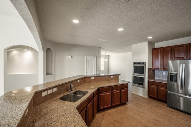 kitchen with light stone counters, recessed lighting, a sink, decorative backsplash, and appliances with stainless steel finishes