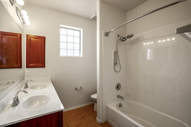 bathroom with tile patterned floors, a textured ceiling, toilet, and a sink