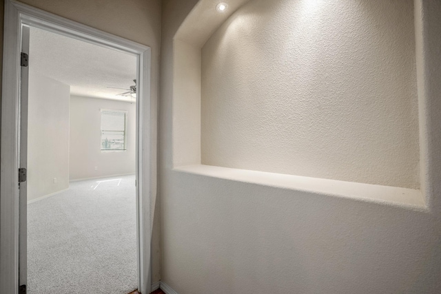 corridor with carpet flooring and baseboards