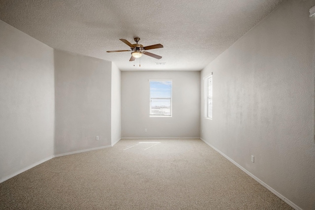 unfurnished room featuring visible vents, baseboards, light carpet, a textured ceiling, and a ceiling fan