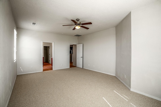 unfurnished bedroom featuring visible vents, baseboards, carpet, and a textured ceiling