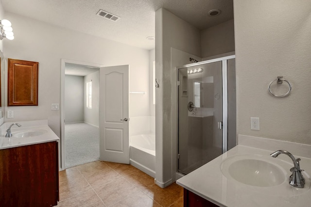 full bath featuring visible vents, a stall shower, a bath, a textured ceiling, and vanity