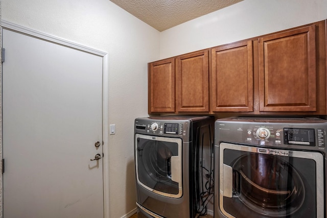 clothes washing area featuring cabinet space, a textured ceiling, and independent washer and dryer