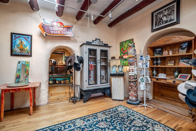 miscellaneous room with beamed ceiling, hardwood / wood-style floors, and rail lighting