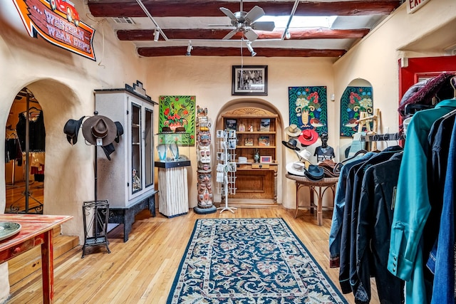 interior space featuring beam ceiling, ceiling fan, and wood-type flooring