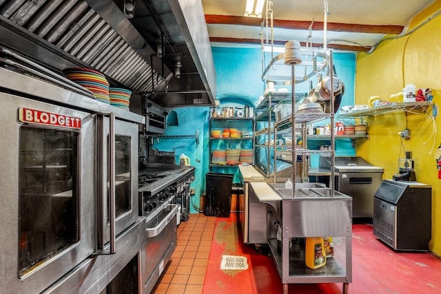 kitchen featuring tile patterned floors, refrigerator, high end stainless steel range oven, and stainless steel counters