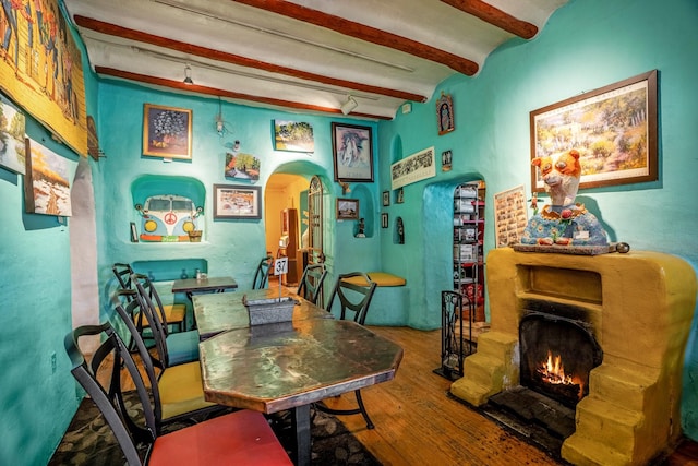 dining room with hardwood / wood-style floors and beamed ceiling