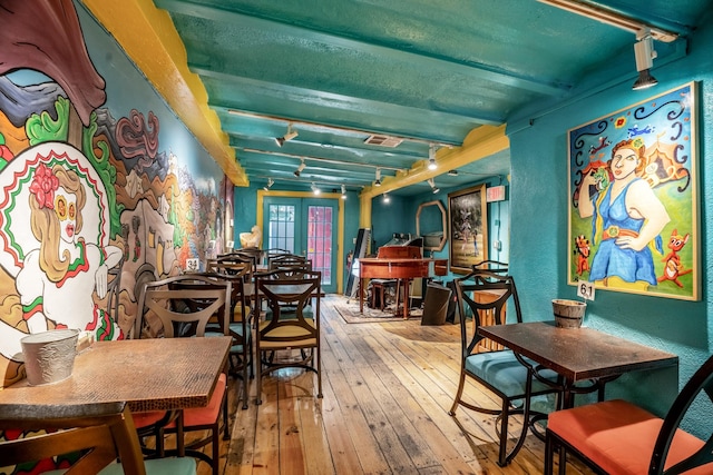 dining room with beamed ceiling and wood-type flooring