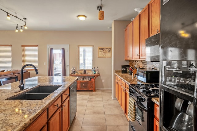 kitchen with light stone countertops, backsplash, sink, black appliances, and light tile patterned floors