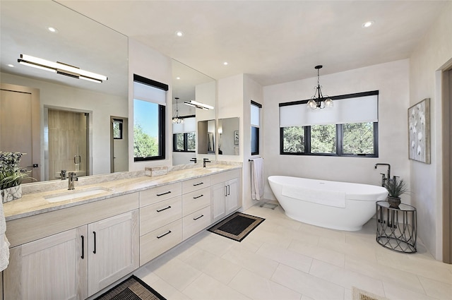 bathroom featuring plus walk in shower, vanity, a notable chandelier, and tile patterned flooring