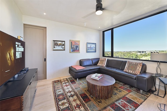 living room with light hardwood / wood-style flooring and ceiling fan