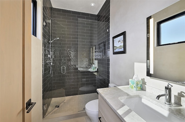 bathroom with toilet, a shower stall, and vanity