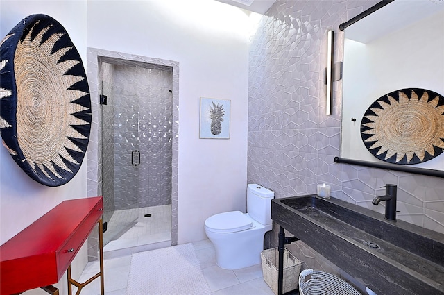 bathroom featuring sink, tile patterned flooring, an enclosed shower, toilet, and tile walls