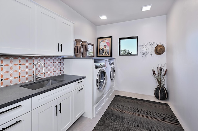 laundry area featuring washer and dryer, light tile patterned floors, cabinets, and sink