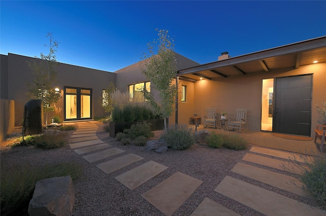 exterior entry at dusk with a patio