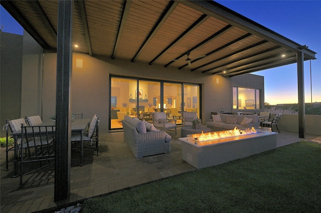 patio terrace at dusk with an outdoor living space with a fire pit