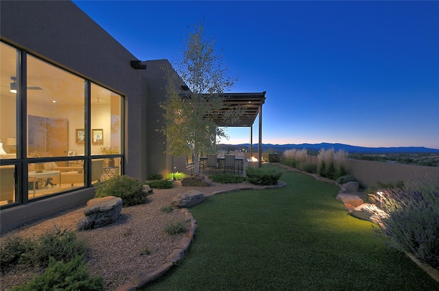 yard at dusk featuring a mountain view