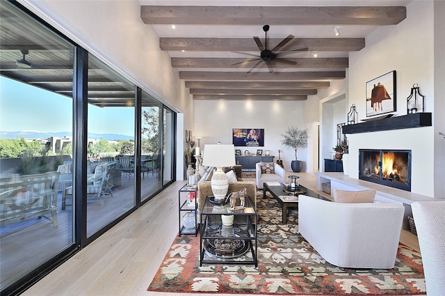 living room featuring beam ceiling, hardwood / wood-style flooring, and ceiling fan