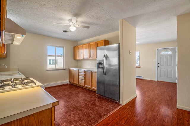 kitchen featuring white range with gas stovetop, stainless steel refrigerator, baseboard heating, and dark wood-type flooring