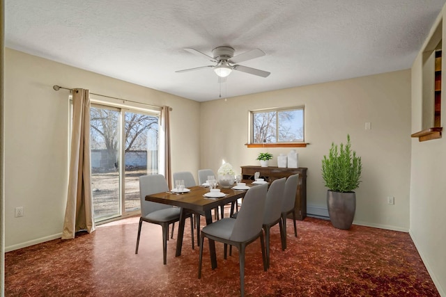 carpeted dining space with ceiling fan and a textured ceiling