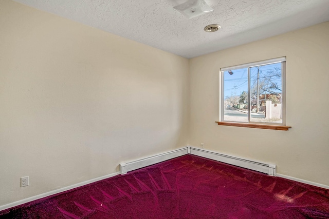 carpeted empty room with a textured ceiling and a baseboard heating unit