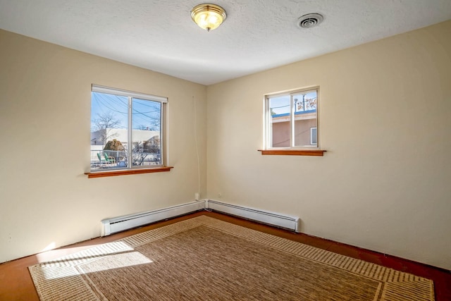 spare room with a textured ceiling and a baseboard radiator