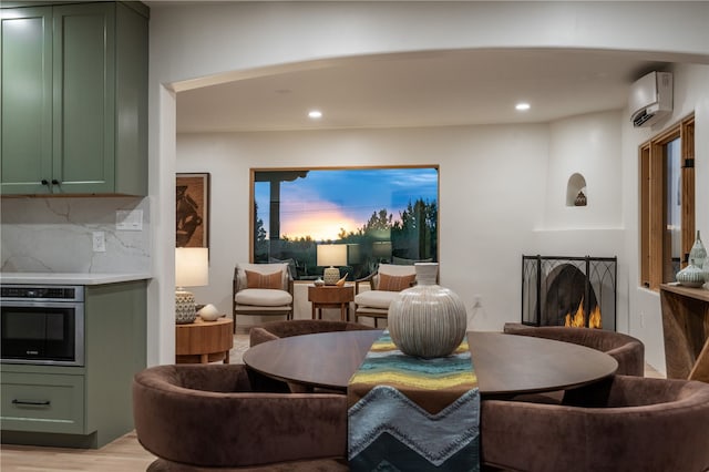 dining space featuring an AC wall unit and light hardwood / wood-style flooring