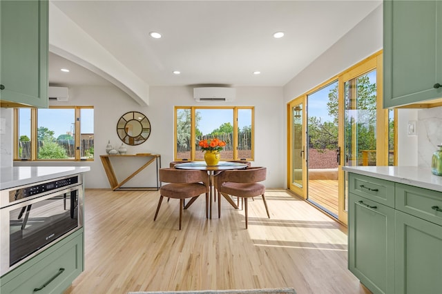 dining space featuring light hardwood / wood-style flooring and a wall mounted AC