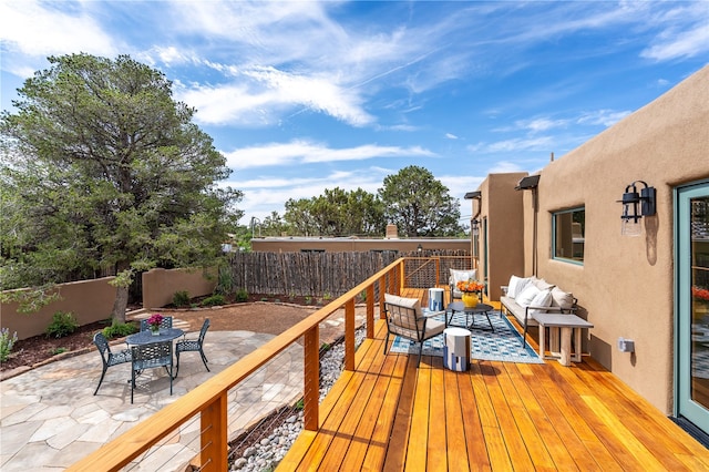 wooden deck featuring outdoor lounge area and a patio